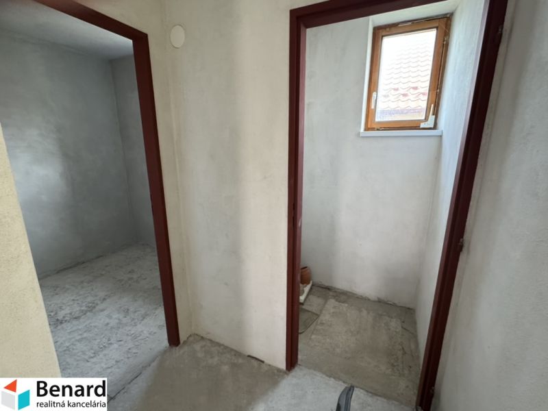 A családi házban két helyiség található betonpadlóval és kis ablakkal.