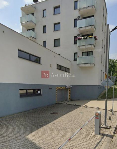 Épület garázzsal a Besztercebányai Švermova utcában, parkoló oszlopok.