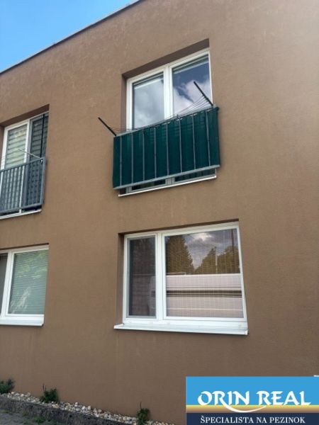 Az épület homlokzata a Tehelnej utcában, Pezinokban, garzonlakás két ablakkal.