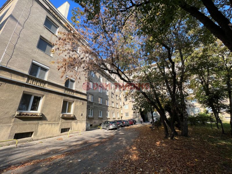 A Miletičova utcai lakóház Pozsony-Ružinovban, fákkal és autókkal körülvéve.
