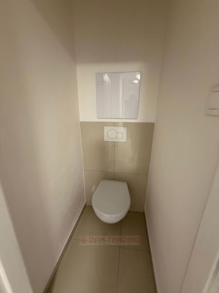 Fürdőszoba WC-vel a kétszobás lakásban, világos falak, kerámia padlóburkolat.