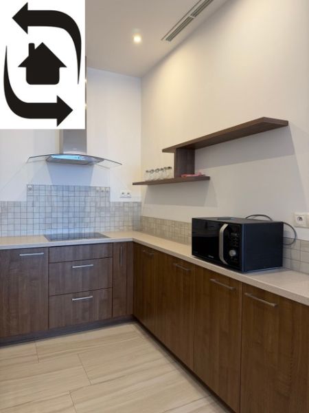 Konyha egy háromszobás lakásban fa dekorációval és beépített készülékekkel.