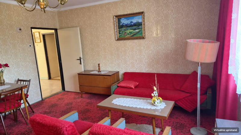 Nappali egy családi házban piros szőnyeggel és retro bútorokkal.