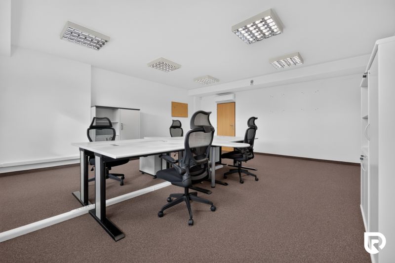 Irodák konferenciaasztallal, ergonomikus székekkel és tárolószekrényekkel.