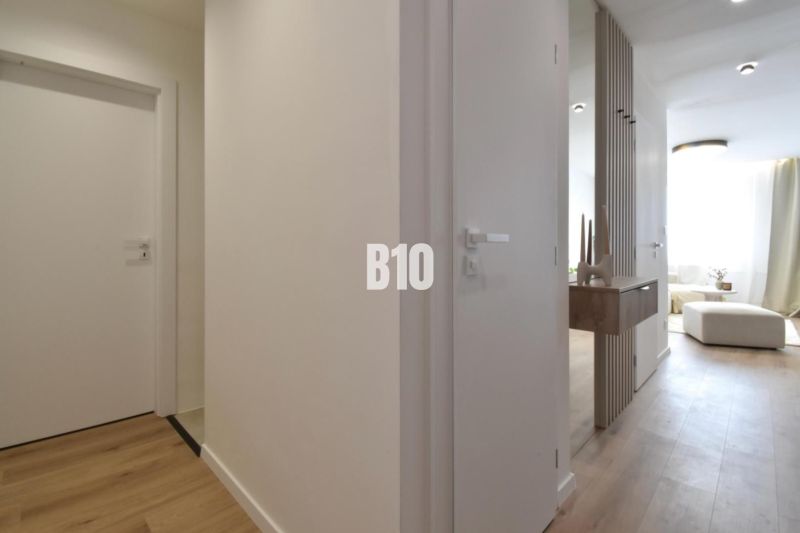 Egy 4 szobás lakás belső tere fa dekor padlóval és minimalista bútorokkal.