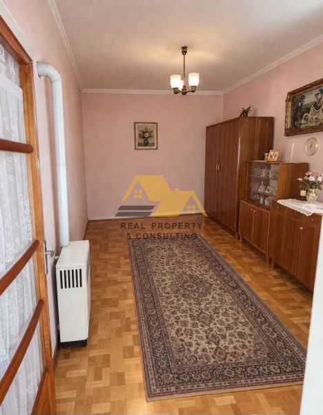 Családi ház belső tere fa dekor padlóval, szőnyeggel és szekrényekkel.