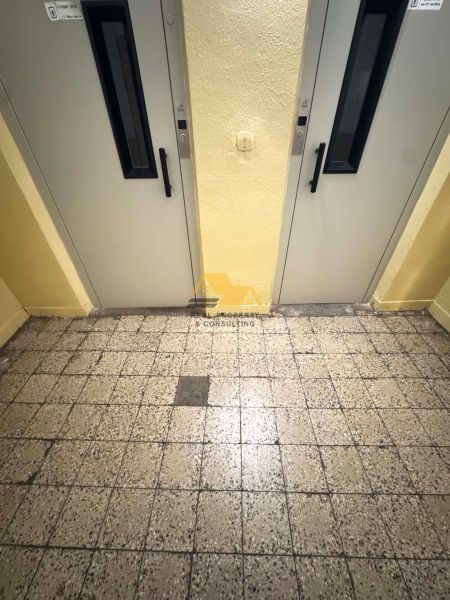 Csempézett folyosó két lifttel egy egyszobás lakásban.