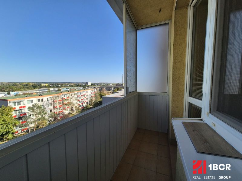 Garzonlakás erkélye kilátással a Bystrická utcára, napos idő Pezinokban.