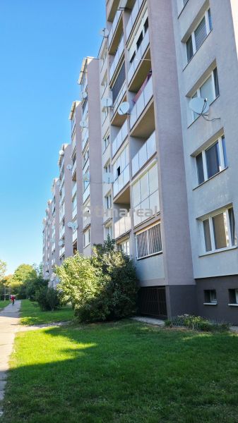 Panelház külső része Nagyszombatban, zöld területtel és járdával a 3 szobás lakáshoz.