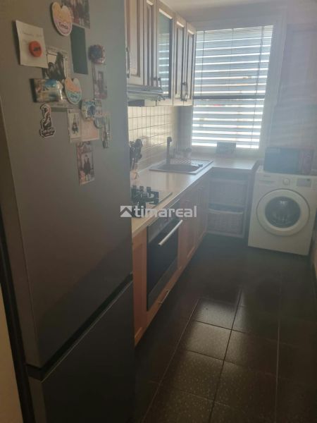 3 szobás lakás konyhája hűtőszekrénnyel, tűzhellyel és mosógéppel.