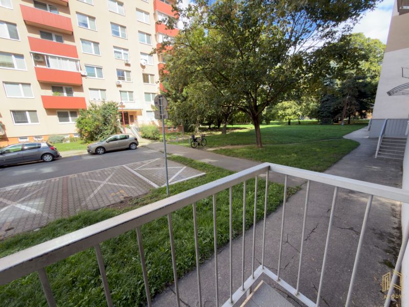 Kilátás a Štefánikova utcára egy 2 szobás lakásból Szenicén, a közeli fákkal.