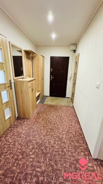 Előszoba szőnyeggel és beépített szekrénnyel egy háromszobás lakásban.