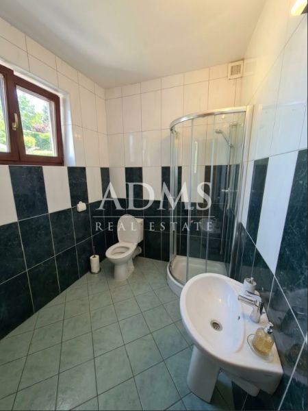 Fürdőszoba WC-vel, zuhanyzóval és mosdóval az iroda helyiségeiben.