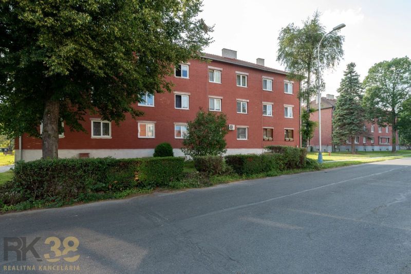 Vörös téglából épült épület zöldövezetben a Svit városában, a Május 9. utcában.
