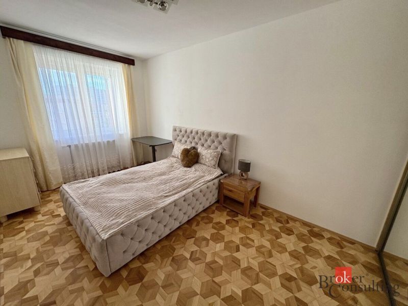 Hálószoba ággyal, éjjeliszekrénnyel és fa dekorációjú padlóval, 3 szobás lakás.