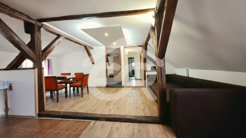 Nyaraló apartman fa dekorációjú padlóval, fa gerendákkal és kényelmes bútorokkal.