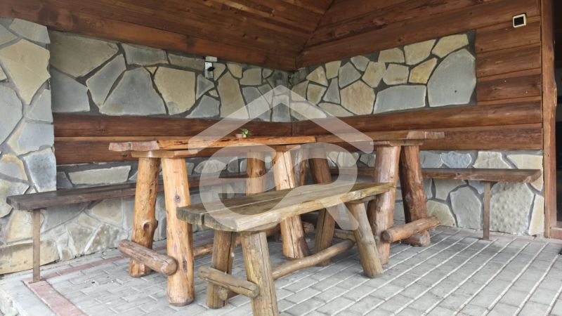 Rusztikus sarok fa bútorokkal és kőfallal a nyaraló apartmanban.
