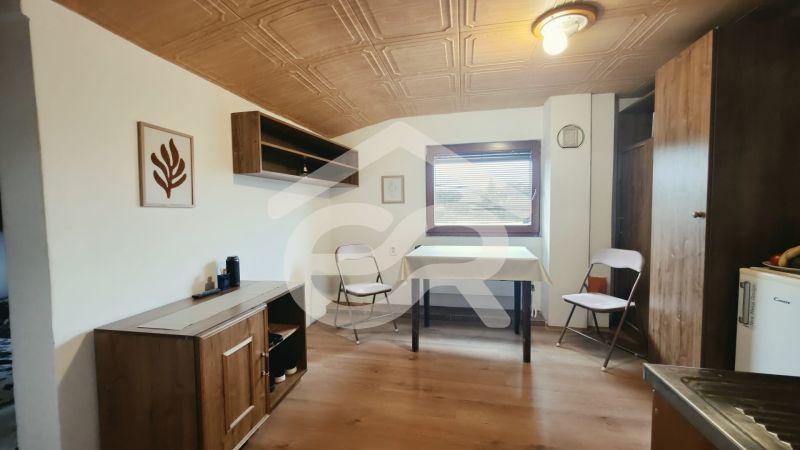 A fa dekorációjú bútorokkal és összecsukható székekkel berendezett üdülő apartman belső tere.