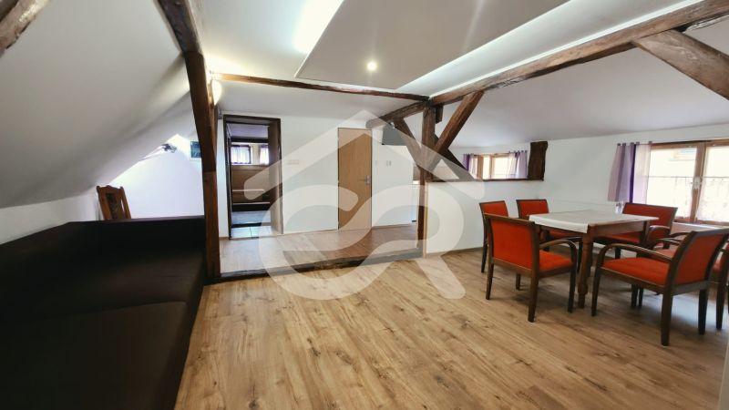 Egy rekreációs apartman fa gerendákkal és fa dekorációjú padlóval étkezősarkot kínál.