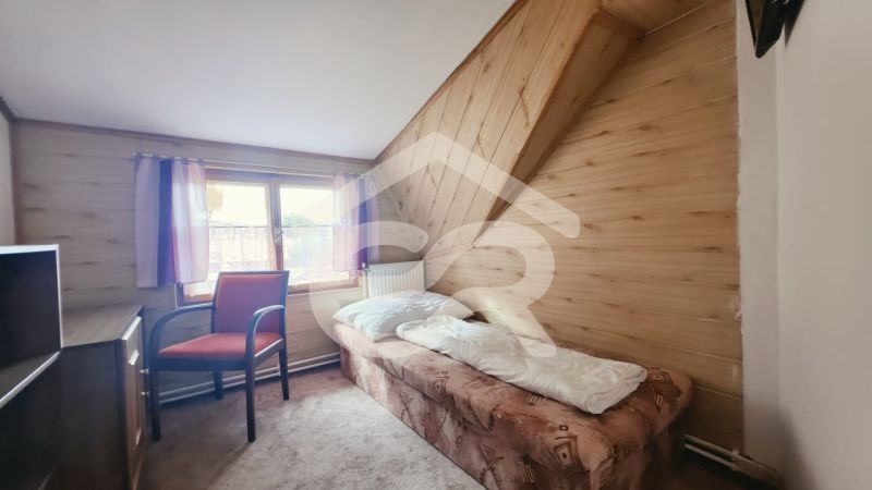 Egylágyas szoba üdülő apartmanban, fa dekorációjú padlóval és ablakkal.