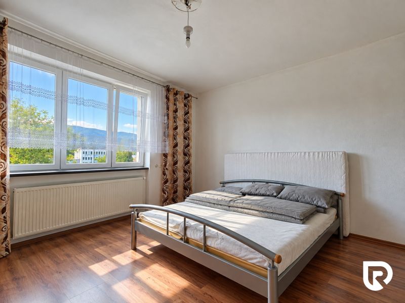 Hálószoba családi házban, ággyal és fa dekorációjú padlóval.