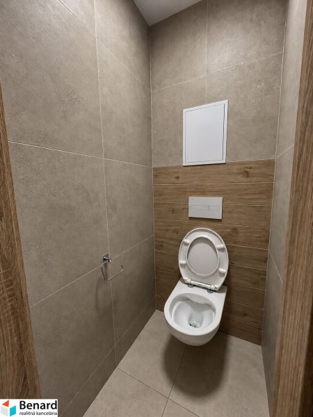 WC kerámia burkolattal és fa dekor padlóval egy 2 szobás lakásban.