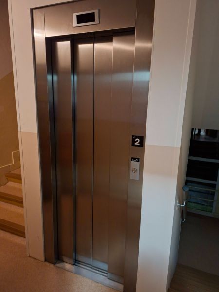 Lift az épületben Prievidzán, a Benedikta utcában, rozsdamentes acél ajtókkal.