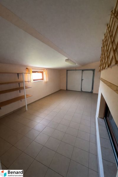 Családi ház belső tere járólappal, tárolópolcokkal és finom függönyökkel ellátott ablakkal.