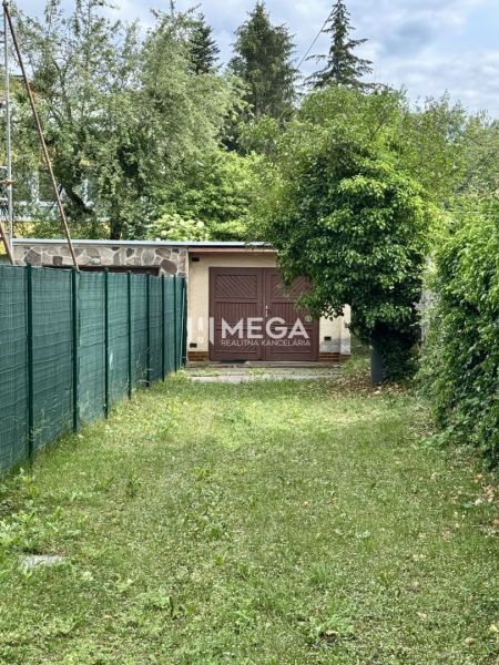 Garázs a Felszabadítók utcában, Homonnán, zölddel és kerítéssel körülvéve.
