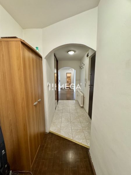 Folyosó egy 3 szobás lakásban csempével és fa dekor padlóval.