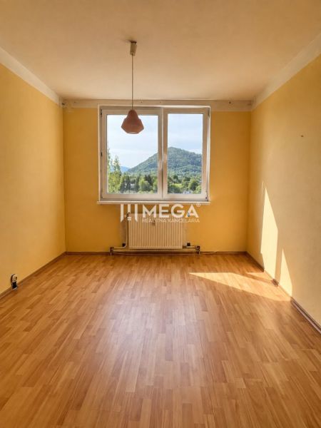 Szoba egy háromszobás lakásban, fa dekorációjú padlóval és nagy ablakkal, kilátással.
