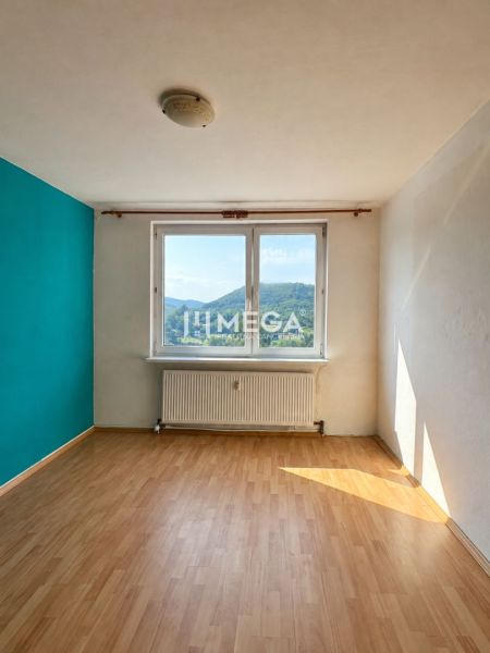 Szoba egy háromszobás lakásban, fa dekorációjú padlóval és kilátással a tájra.