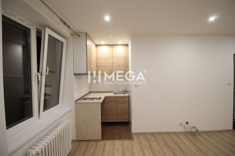 Konyha egy üdülő apartmanban konyhabútorral és fa dekorációjú padlóval.
