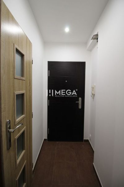 Rekreációs apartman bejárata világos falakkal és fa dekorációjú ajtókkal.