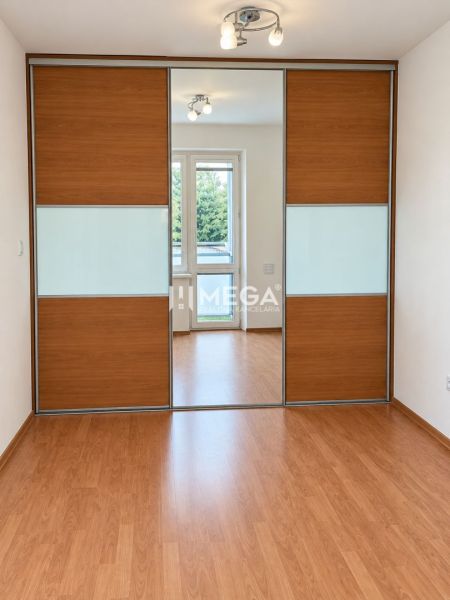 Fa dekorációjú padló, beépített szekrény és lámpatest egy kétszobás lakásban.