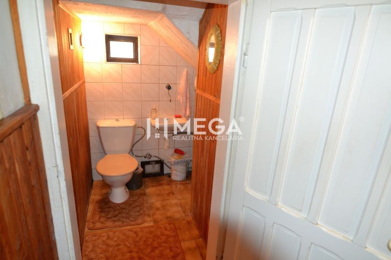 WC csempével és kis ablakkal egy családi házban.