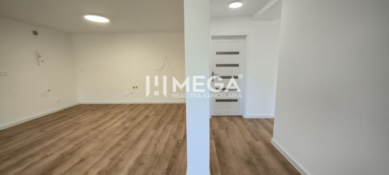Tágas tér világos falakkal és fa dekorációjú padlóval egy 4 szobás lakásban.