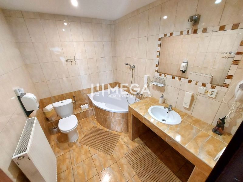 Fürdőszoba szállodákban és panziókban káddal, WC-vel és nagy tükörrel.