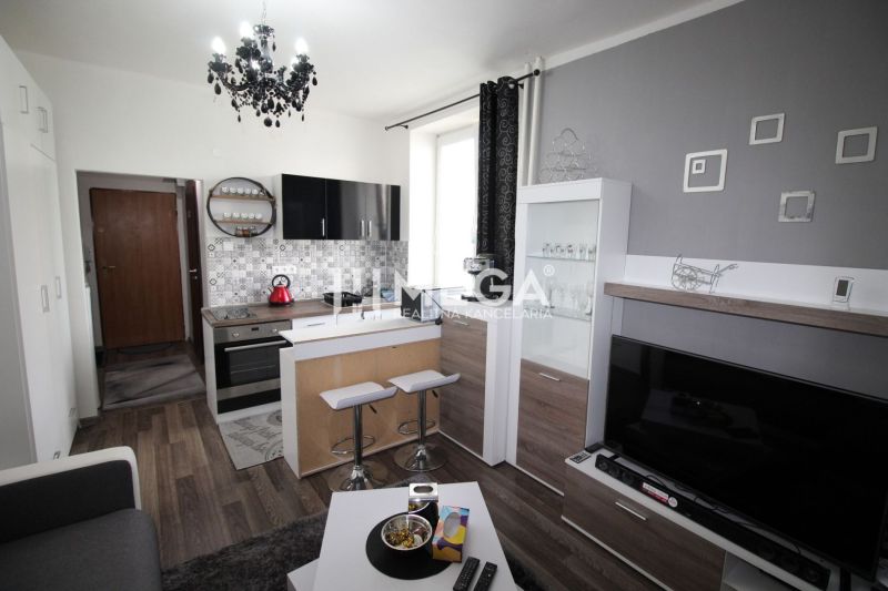 Konyha a nyaraló apartmanban kanapéval és fa dekorációjú padlóval.