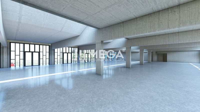 Nagy üvegcsarnok kereskedelmi helyiségekben beton oszlopokkal és sima padlóval.