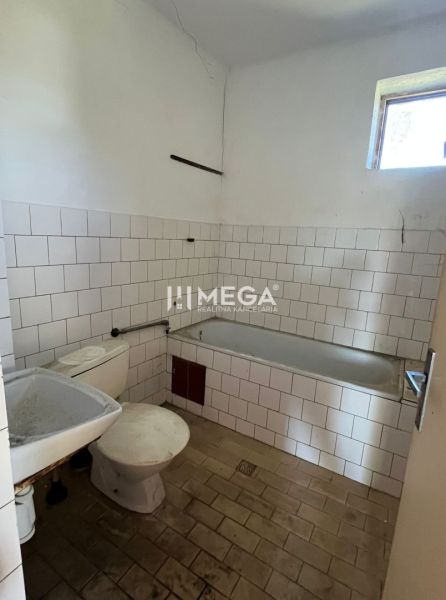 Fürdőszoba zuhanyzóval és WC-vel egy családi házban, alapvető belső tér fehér csempékkel.