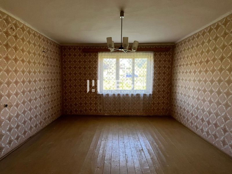 Szoba tapétával és fa dekor padlóval egy családi házban.