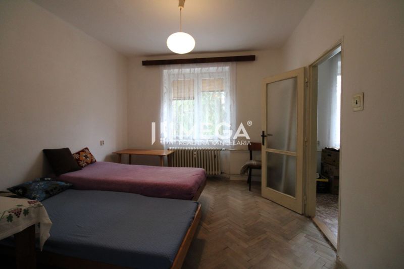 Hálószoba két ággyal és fa dekoros padlóval egy kétszobás lakásban.