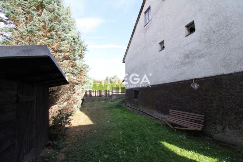Kert egy családi ház mellett a Volica utcában, Volica városában, paddal és tűlevelű fákkal.
