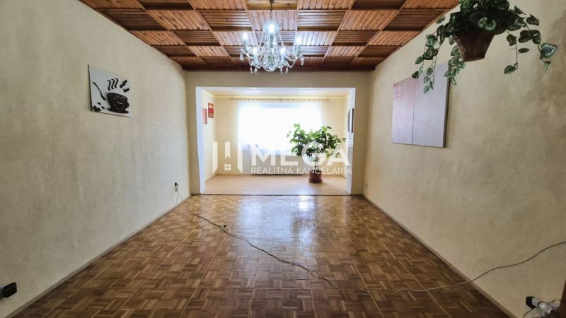 Nappali egy családi házban, fa dekorációjú padlóval és csillárral.