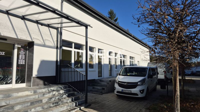 Épület üzlethelyiségekkel a humennéi Tyršova utcán, parkoló autók, fa.