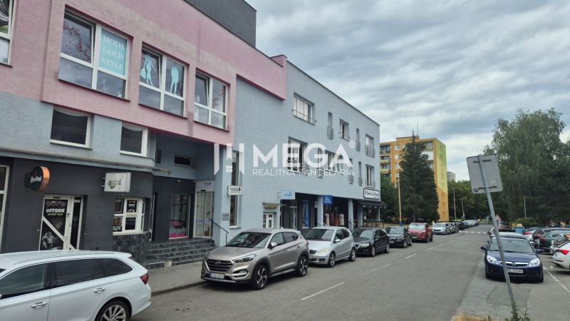 Üzletekkel és irodákkal rendelkező épületek a Felszabadítók utcában, Humenné, parkoló autók.