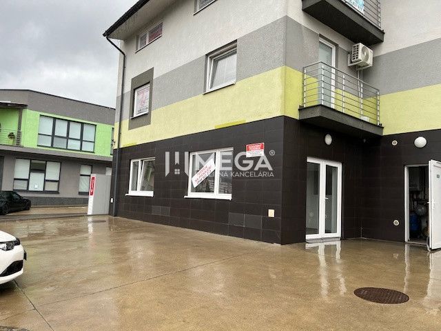 Üzlethelyiség a Komenského utcában, Sninában, modern homlokzattal és erkéllyel.