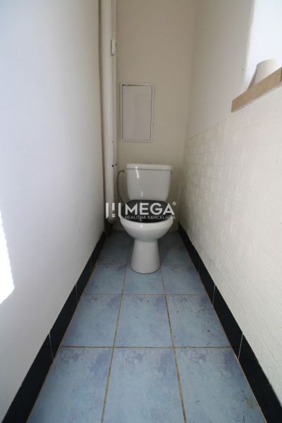 Fürdőszoba egy háromszobás lakásban WC-vel és kék csempével.