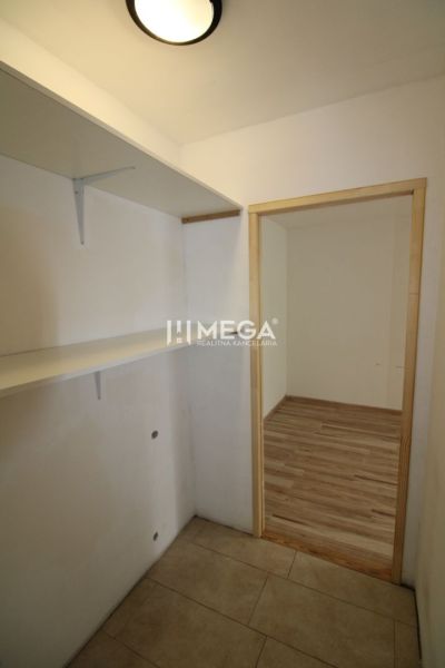 Előszoba polcokkal és fa dekorációjú padlóval egy háromszobás lakásban.